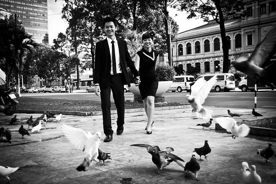 Couple Shoot Saigon - couple walk through pigeons