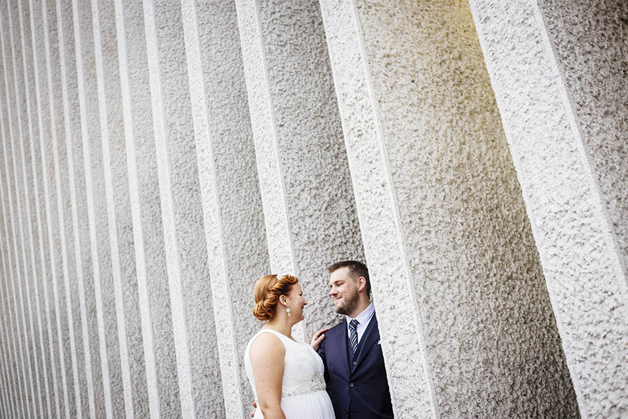 Embassy Wedding - Portrait of newlyweds with concrete facade